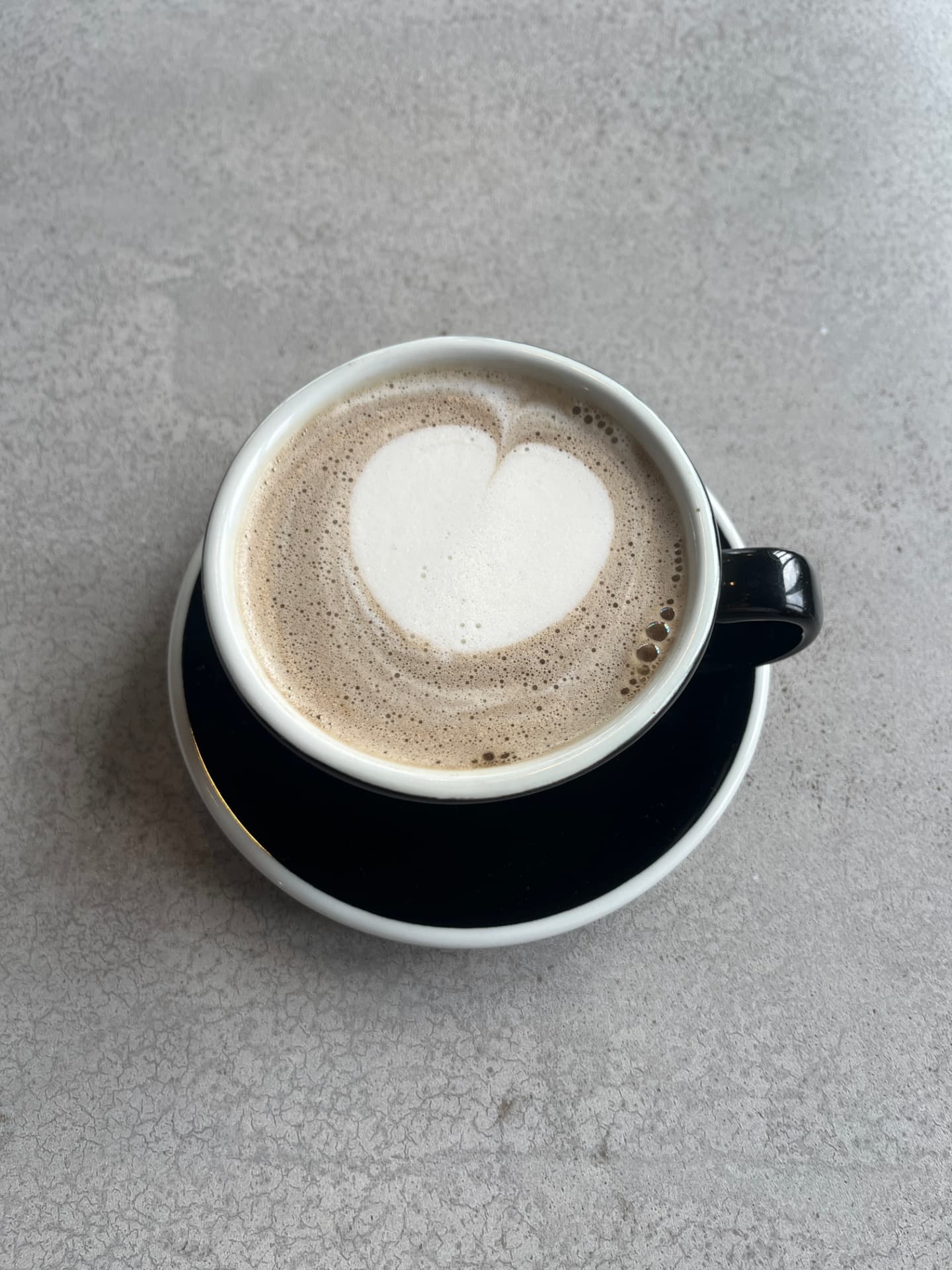 Mugwort matcha latte with heart latte art in a black cup