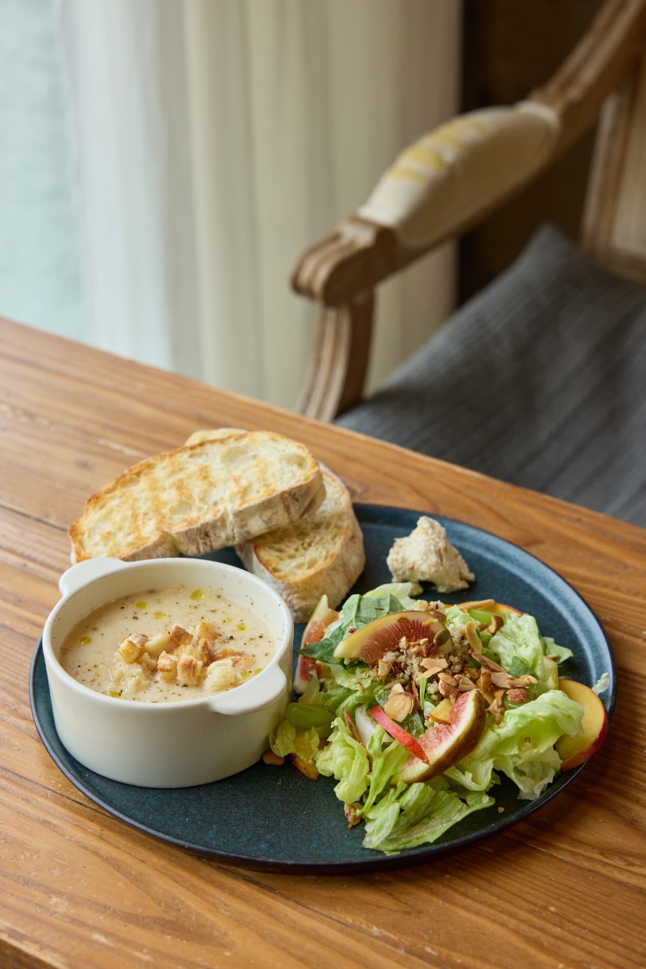 Brunch bowl with fig salad, dressing, and a wrapped 901 sandwich
