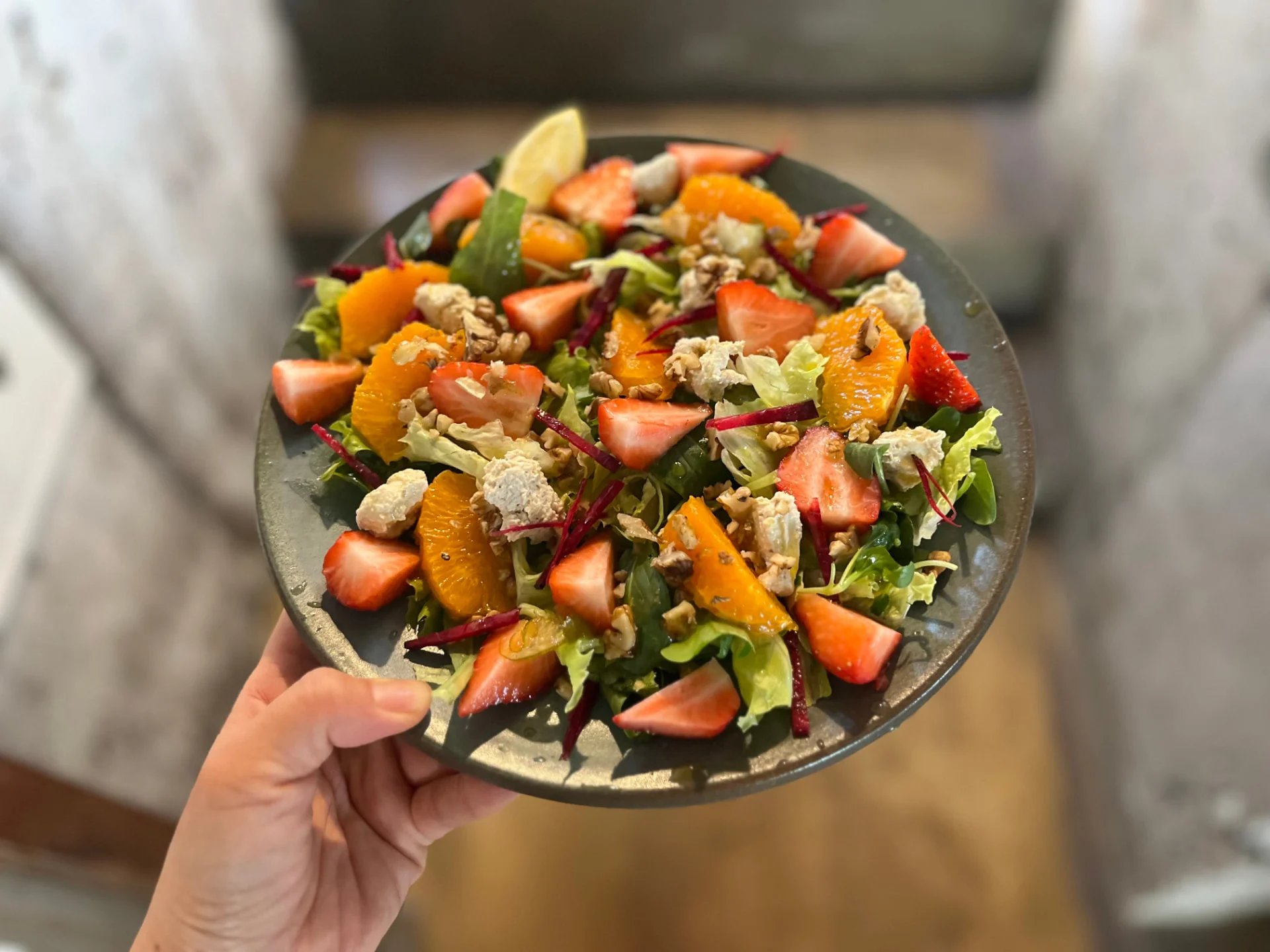A seasonal salad with strawberries, tangerines, walnuts, and tofu crumble
